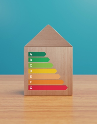 Étiquette énergie DPE de A à G sur une maquette de maison